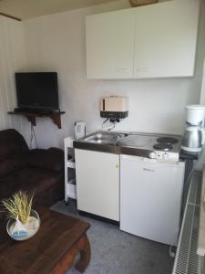 a small kitchen with a stove and a couch at Bungalow in strandnähe in Mönkebude