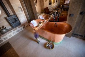 een grote badkamer met een houten bad en een wastafel bij Mirsoum Hotels in Mardin
