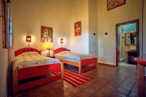 a bedroom with two beds and a bathroom at Hosteria Museart Pantavi in Tumbabiro