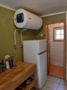 a kitchen with a refrigerator and a camera on the wall at Kipi-Koovi Matkakeskuse väiksem majake in Kipi