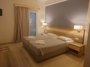 una camera d'albergo con letto e finestra di Ifigenia Hotel a Città di Skiathos
