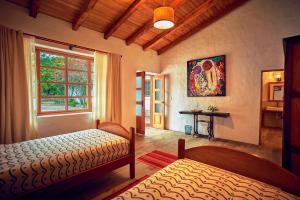 1 dormitorio con cama, ventana y mesa en Hosteria Museart Pantavi, en Tumbabiro