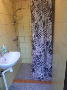 a shower curtain in a bathroom with a sink at Kipi-Koovi Matkakeskuse väiksem majake in Kipi