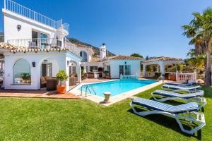 a villa with a swimming pool and lounge chairs at Casa Media Luna, Mijas Malaga in Mijas