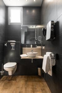 a bathroom with a sink and a toilet at Hôtel Restaurant & Spa Plaisir in Le Bois-Plage-en-Ré