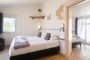 a bedroom with a large bed and a window at Hôtel Restaurant & Spa Plaisir in Le Bois-Plage-en-Ré