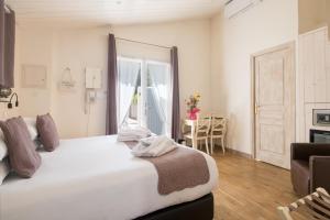 a bedroom with a large white bed and a window at Hôtel Restaurant & Spa Plaisir in Le Bois-Plage-en-Ré
