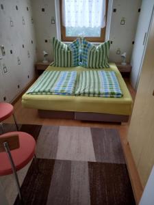 シュミーデフェルト・アム・レンシュタイクにあるRennsteigwohnung Rustの小さなお部屋で、ベッド1台(緑のソファ付)が備わります。