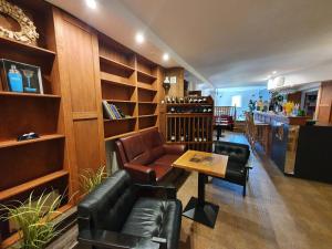a bar with leather chairs and a table in a room at Relax Penzion U Adama in Dolná Tižina