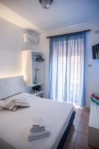 a bedroom with a bed with two towels on it at Baron Beach Hotel in Scauri