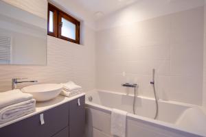 a white bathroom with a tub and a sink and a bath tub at Les Pimprenelles in Carcassonne