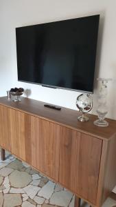 a flat screen tv sitting on top of a wooden entertainment center at Casa Di Marco in Como
