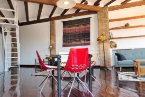 a living room with red chairs and a table at Loft el Carmen amazing views in Valencia