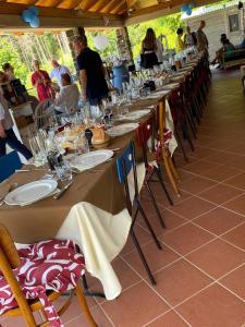 a row of tables with chairs and people sitting around them at Alla tana del bianconiglio in Prataccio