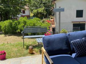a blue couch and a bench in a yard at Alla tana del bianconiglio in Prataccio
