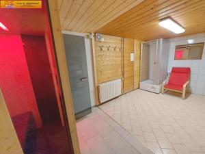 an empty room with a red chair and a door at Haus Sandlweber by FiS - Fun in Styria in Bad Mitterndorf