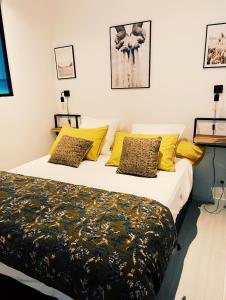 a bedroom with a large bed with yellow pillows at Chez Garance Saint-Tropez in Saint-Tropez