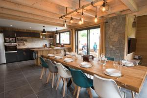 uma sala de jantar com uma grande mesa de madeira e cadeiras em TOUT NEUF - Chalet Pébie 8 à 10 pers avec sauna em La Bresse