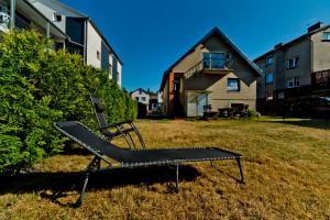 a bench sitting in the grass in front of a house at Kwatery Prywatne am Meer in Władysławowo