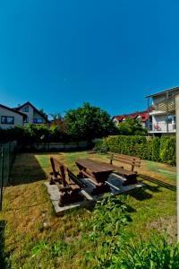 a picnic table and benches in the grass at Kwatery Prywatne am Meer in Władysławowo