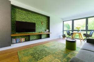 ein Wohnzimmer mit einer grünen Wand und einem TV in der Unterkunft Das Andere - Gästeapartment in Kippenheim