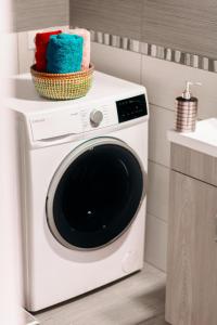 a white washing machine with a basket on top of it at Sea Breeze Flat in Kavála