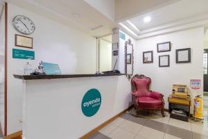 a waiting room with a red chair and a clock at Ayenda 1043 Kafir in Bogotá