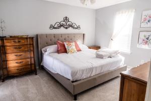 a bedroom with a bed with a chandelier and a dresser at University Escape with hot tub and fire pit in University Place