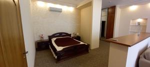 Una habitación de hotel con una cama en una habitación en Tropicana Hotel, en Primorsko-Akhtarsk