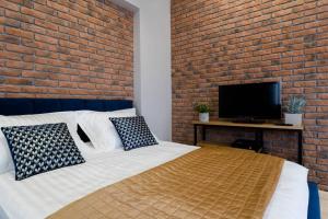una camera con letto e muro di mattoni di Apartament w ścisłym centrum miasta. a Lublino