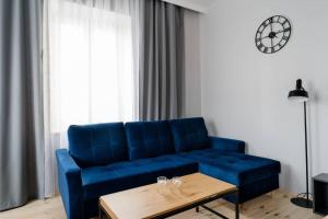un divano blu in soggiorno con tavolo di Apartament w ścisłym centrum miasta. a Lublino
