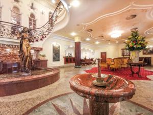 a lobby with a statue in the center of a building at Carlsbad Plaza Medical Spa & Wellness hotel in Karlovy Vary