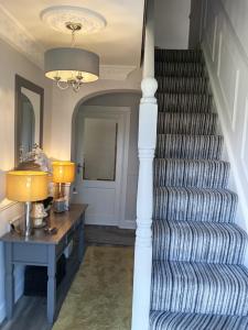 a staircase with a table and two lamps on it at Murrayville B&B in Achill Sound