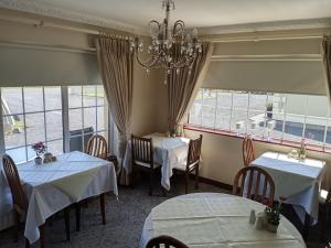 a dining room with two tables and a chandelier at Murrayville B&B in Achill Sound +8 photos