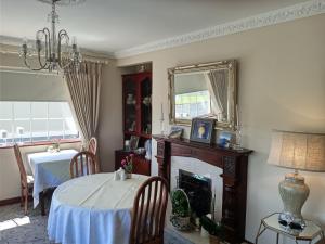 uma sala de jantar com uma mesa e uma lareira em Murrayville B&B em Achill Sound