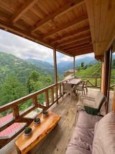 una terraza de madera con mesa y sillas. en Vadi dağ evi bungalov en Çamlıhemşin