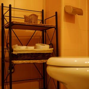 a bathroom with a toilet and a shelf with towels at Locanda Al 5 in Lainate