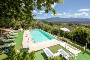 a swimming pool with chairs and a view of the mountains at Villa le Casine in San Cristoforo a Perticaia