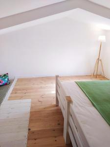 1 dormitorio con 1 cama y suelo de madera en Hotel Galman, en Carloforte