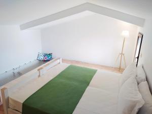 una camera con un letto e un tappeto verde di Hotel Galman a Carloforte