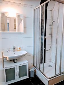 a bathroom with a glass shower and a sink at Dat lütte Strandhuus in Cuxhaven
