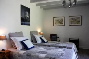 a bedroom with two beds and two chairs at La Butte de Gohier in Blaison