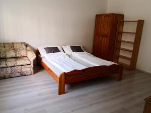 un letto in legno in una camera con divano di OASIS APARTMAN II. a Szeged