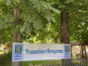 uno striscione appeso a due alberi in un parco di Kastanienhof a Müglitztal