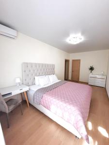 a bedroom with a large bed and a desk at Alex Apartment Сеть апартаментов Бесконтактное заселение 24-7 in Poltava
