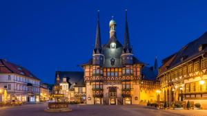 an old building with a clock tower at night at FeWo Am alten Holzplatz in Drübeck