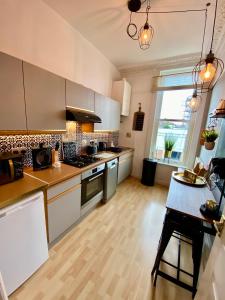 a kitchen with stainless steel appliances and a wooden floor at Ann Apartments opposite the Pier with sea view in Portsmouth