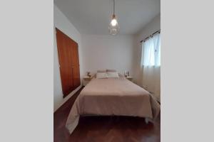 - une chambre blanche avec un lit dans l'établissement Excelente ubicación en el Bv. más lindo de Rosario, à Rosario