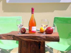 a bottle of wine and two glasses on a wooden table at Dourios Ippos Apartments in Frikes