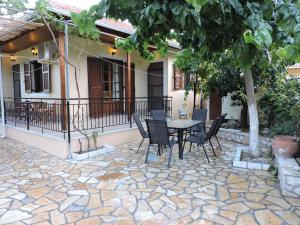 a patio with a table and chairs in front of a house at Calm house in Sivros village, Lefkada in Sívros
